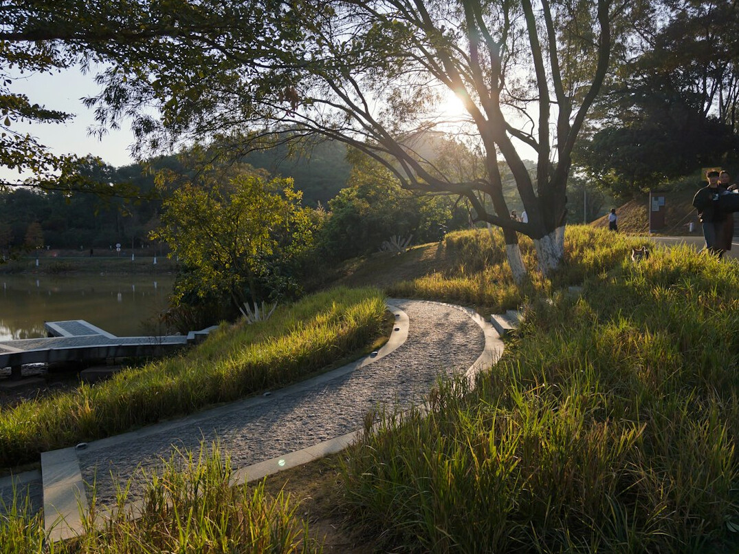 Older couple walking on a morning path in a park with hills behind
