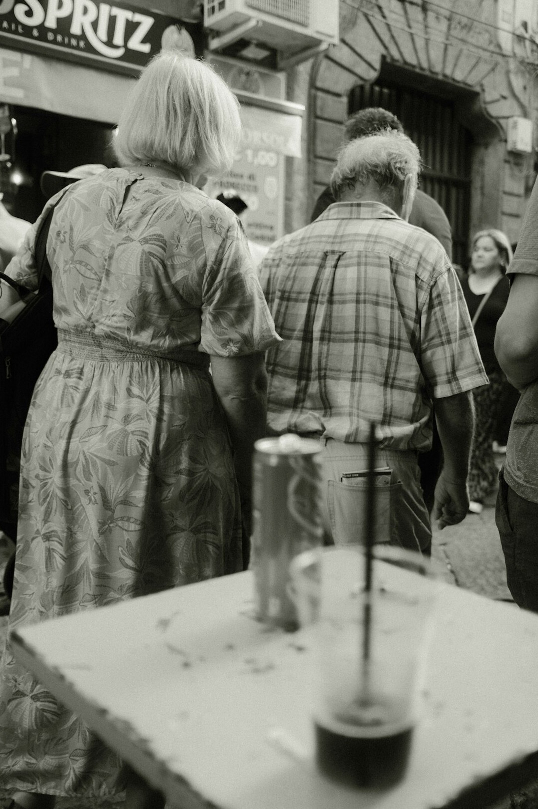 Two older Latin American women laughing together at a cafe table