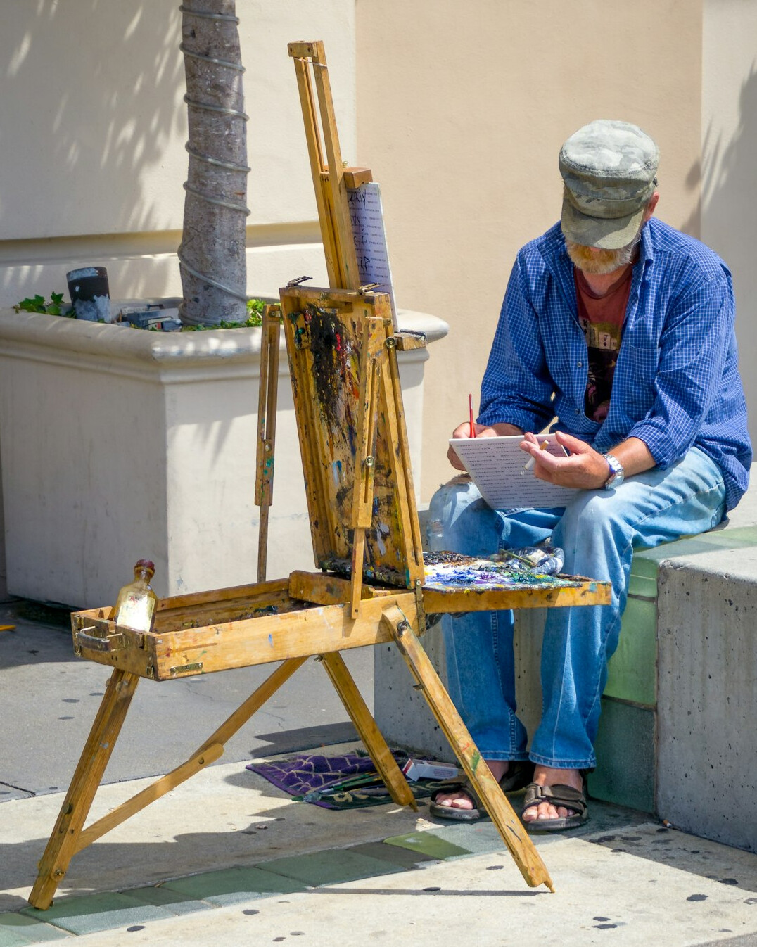Older Latin American woman painting with watercolors at an easel